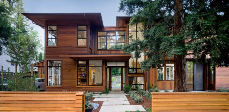 Street elevation of the Palo Alto 3 House, a two-storey cedar-clad home behind a horizontal slatted fence with a redwood beside the entry walk.